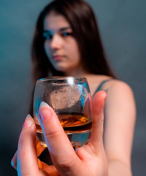 девушка держит в руке стакан с алкоголем