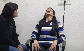 Пациентка в кресле во время сеанса гипноза